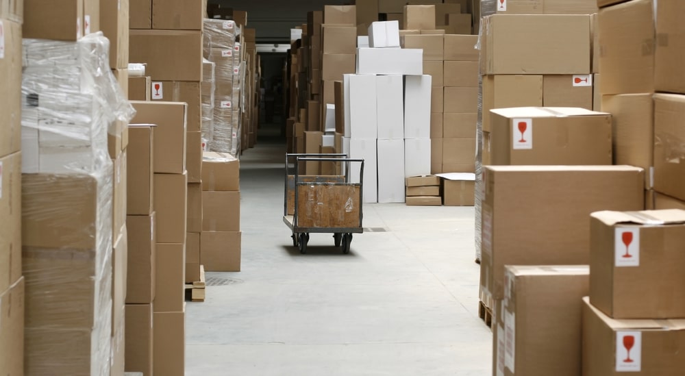 Boxes in a backroom showcasing excess inventory, one of the eight wastes of Lean.